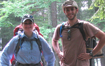 man and woman with hiking gear in a forest
